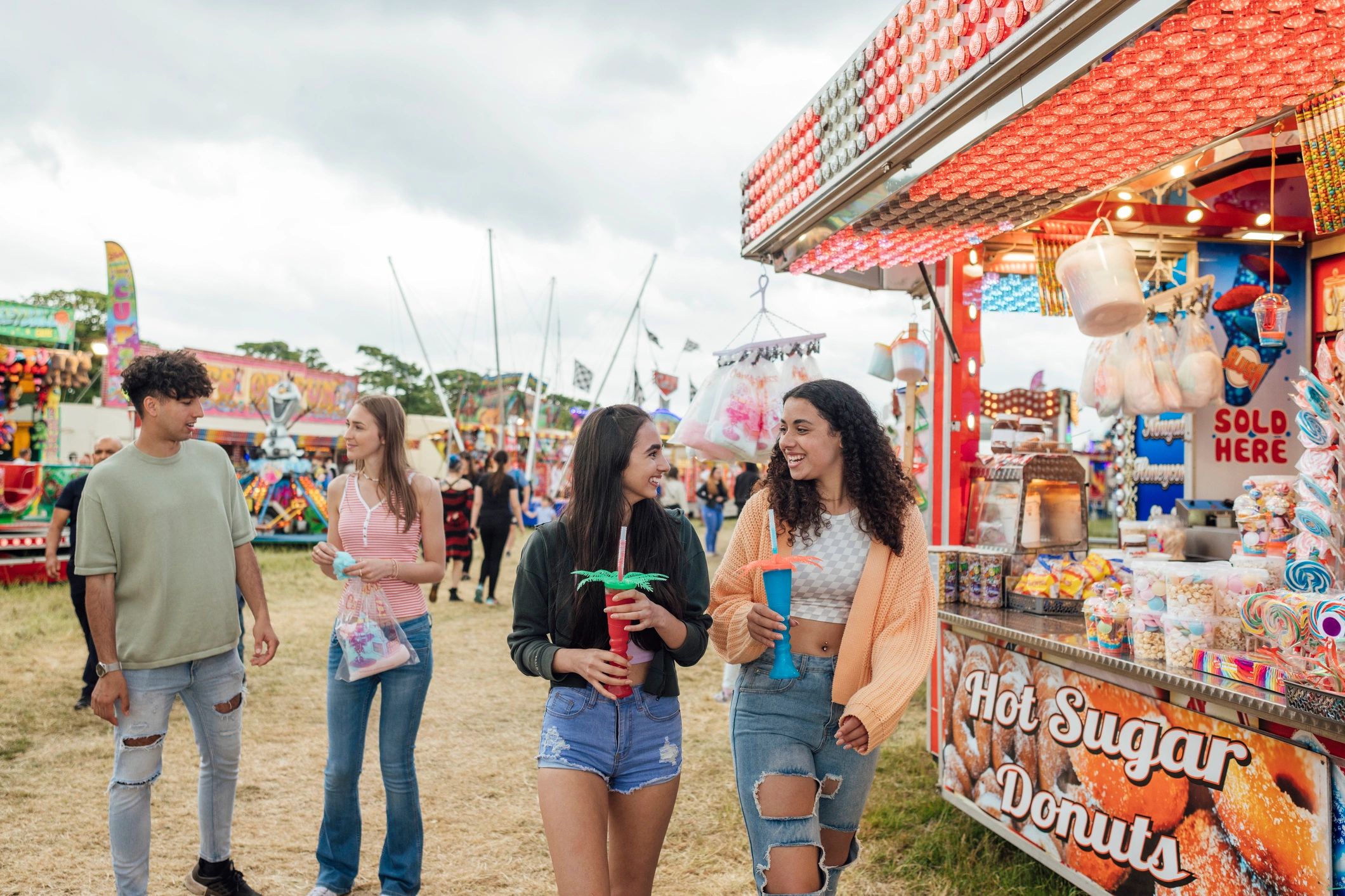 Jóvenes disfrutando bebidas y snacks en una feria